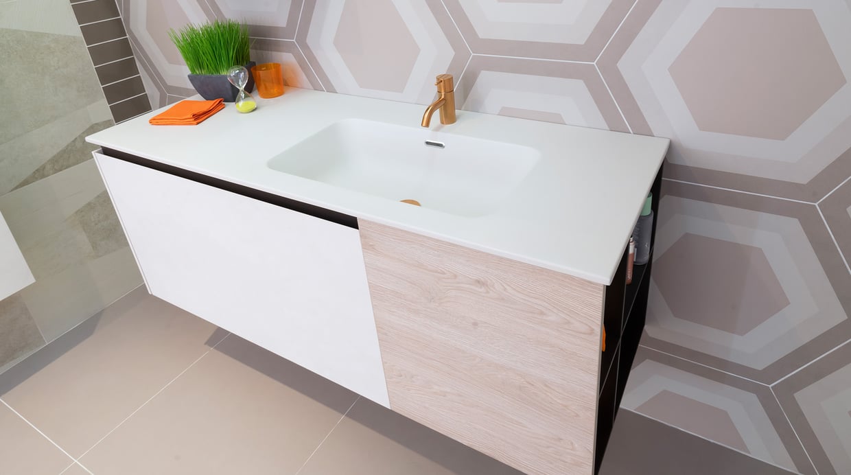 White solid surface vanity top with mixed material storage below