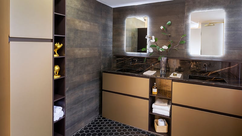 A bathroom with golden color floor mounted vanities with brown edges