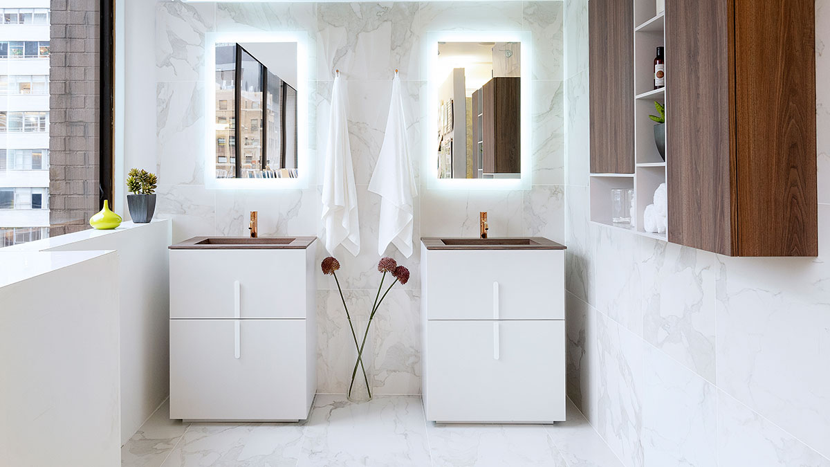 Two freestanding white vanities with backlit mirrors