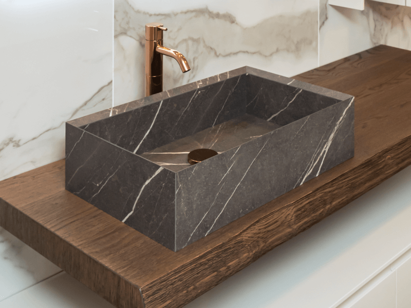 marble-look bathroom vessel sink with gold faucet
