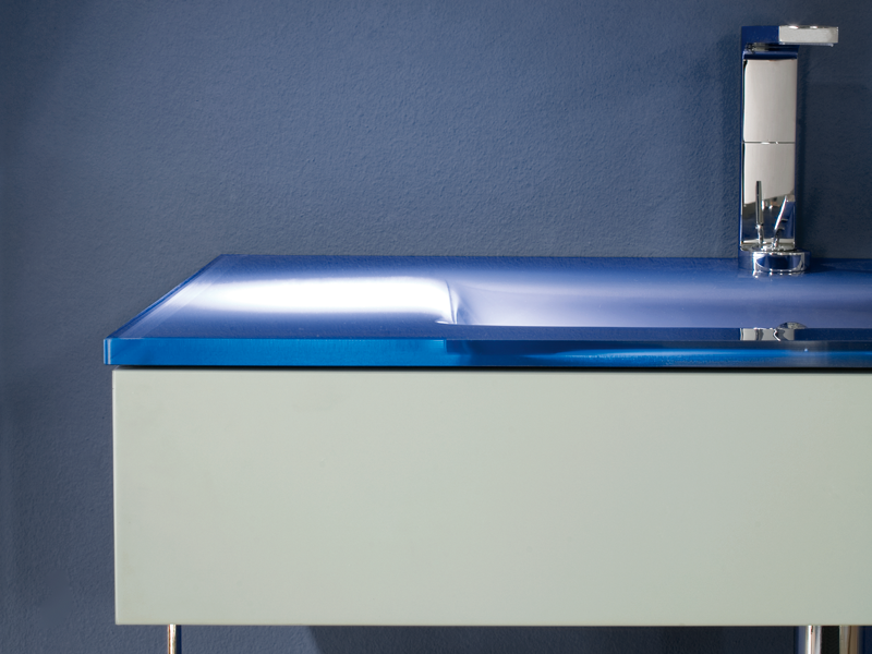 Closeup of a blue glass countertop with an integrated basin
