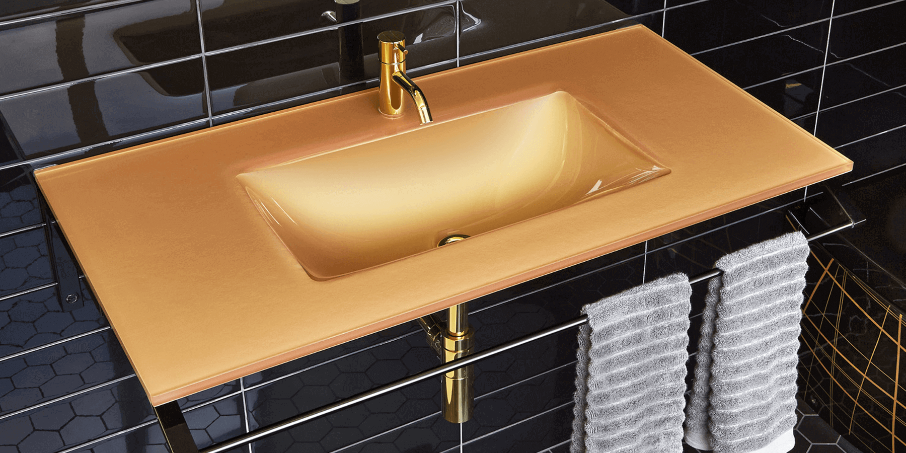 A gold-colored glass basin with a brass faucet