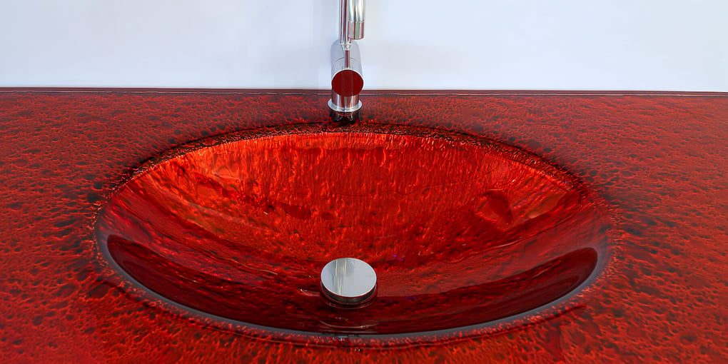 Closeup of a red glass countertop in a luxury bathroom vanity