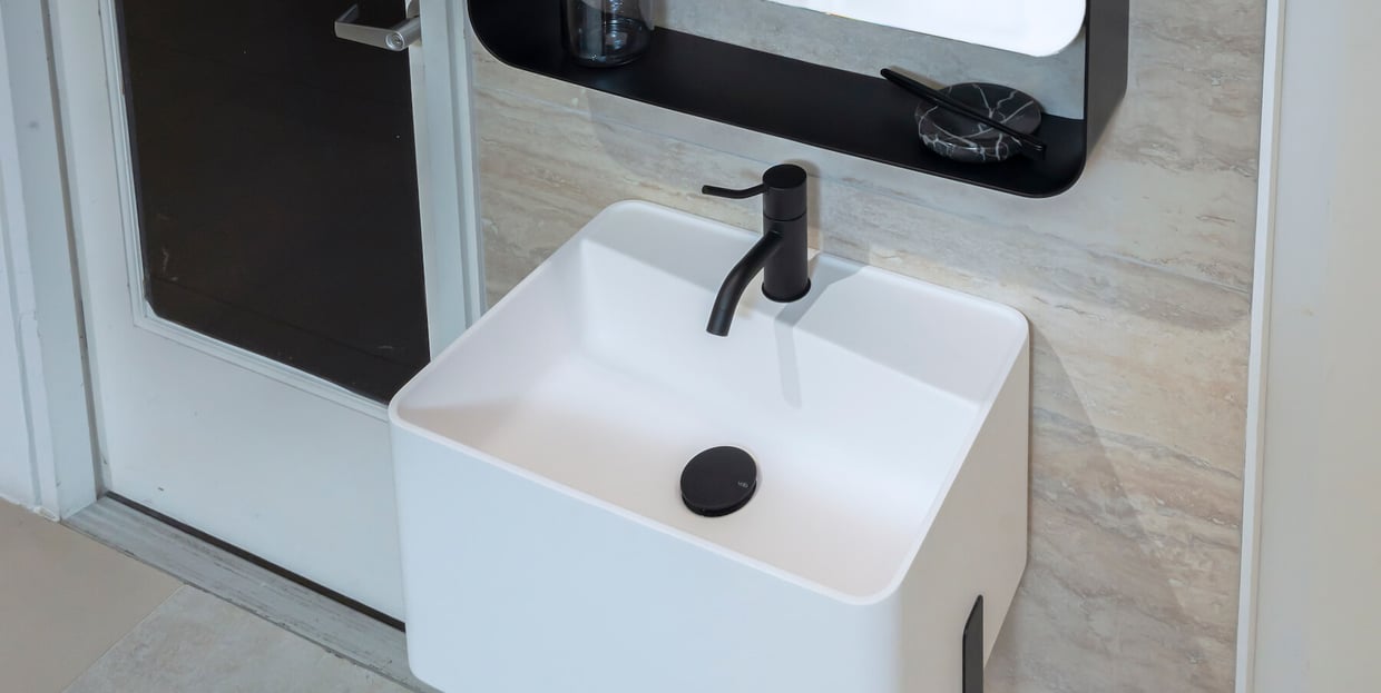 Black VOLA basin faucet on white basin