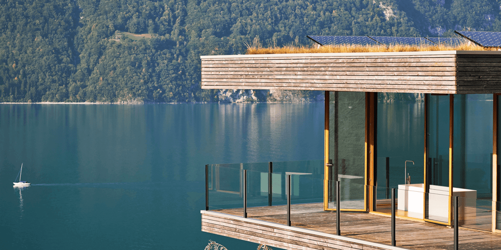 A luxury bathtub with VOLA tub filler and a lake view