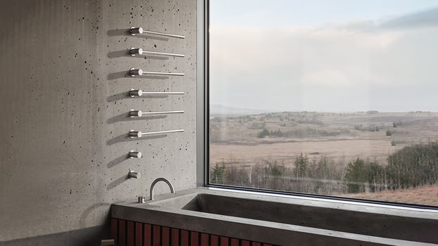 Six VOLA towel heaters mounted on a concrete wall in a bathroom with a beautiful view