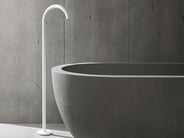 White freestanding VOLA tub filler with grey bathtub