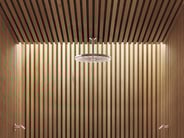 A rain-style VOLA showerhead in a wood-paneled shower