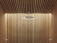 A rain-style VOLA showerhead in a wood-paneled shower