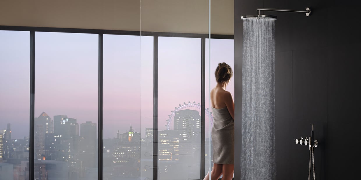 VOLA rainhead shower in a bathroom overlooking a city skyline