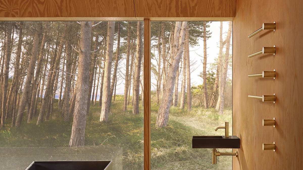 A four-bar VOLA towel warmer in a bathroom with a forest view