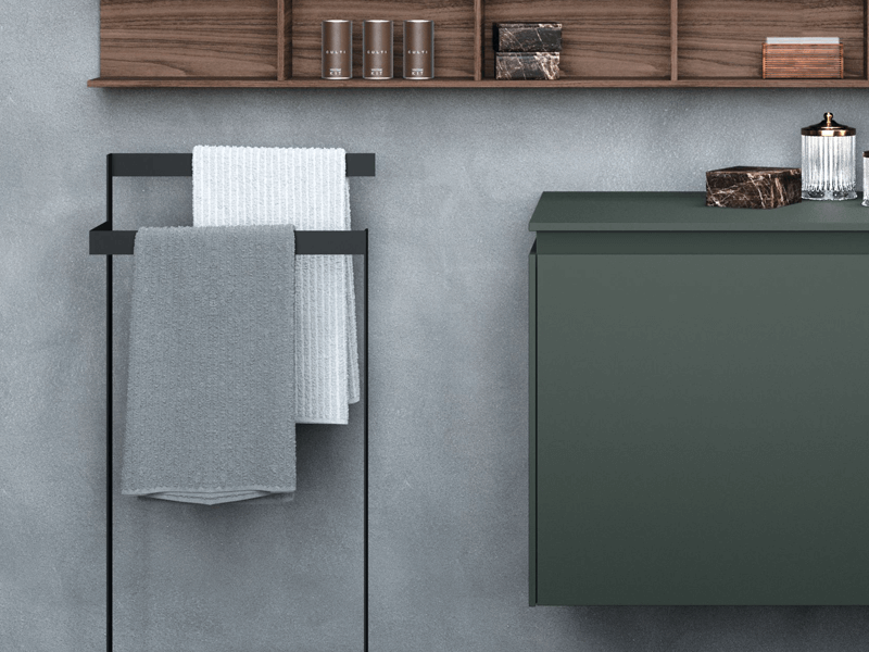 Black towel rail beside a green vanity