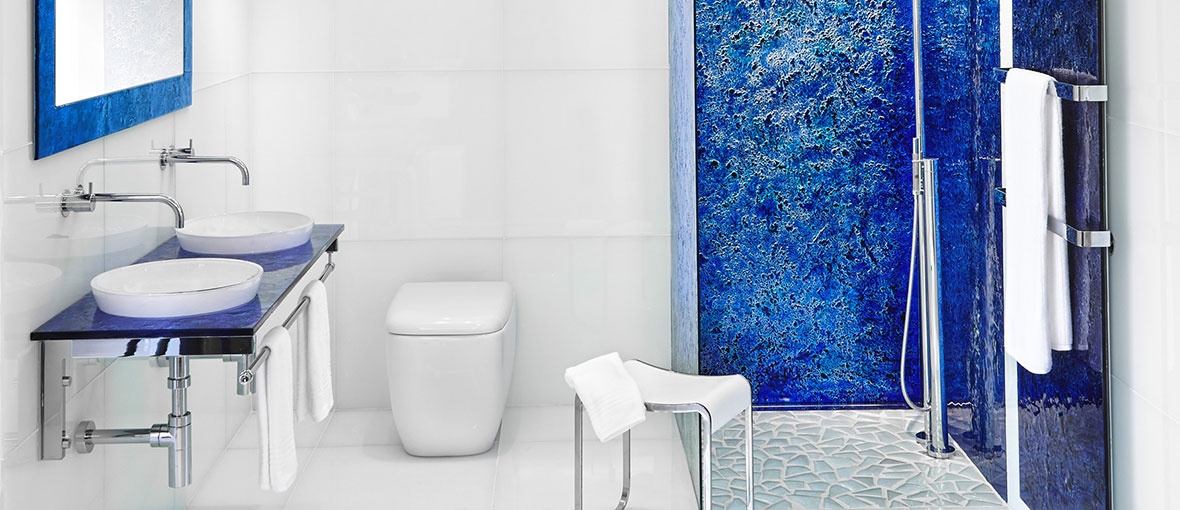 An ocean blue colored Vetro glass countertop in a luxury bathroom