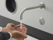 Person washing hands under VOLA hands-free faucet