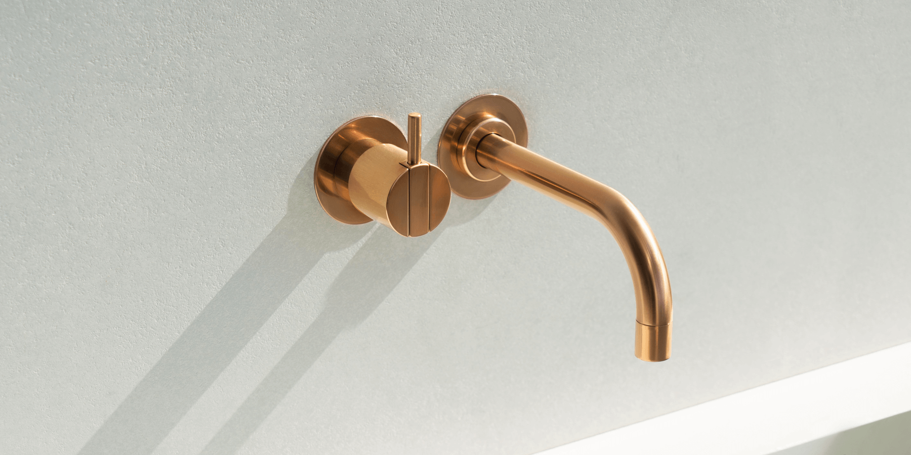 Bronze VOLA Faucet mounted on a wall above a sink