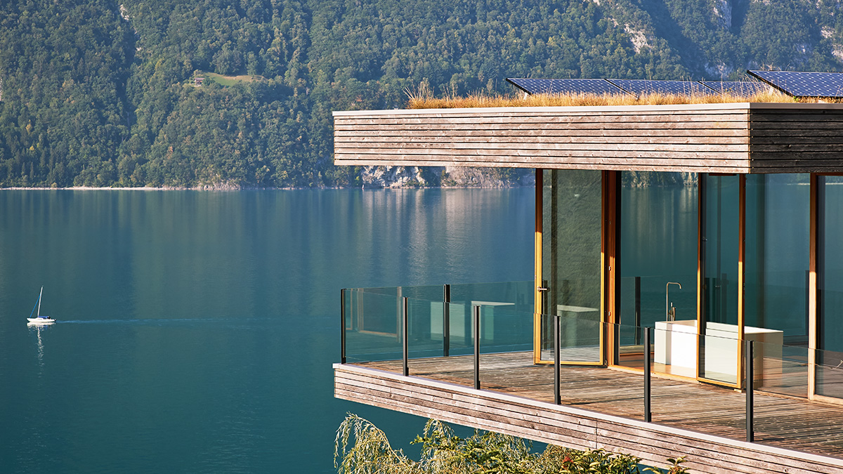 A bathroom perched against a lake backdrop with a VOLA filler visible on the bathtub