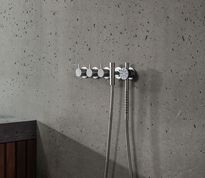 Wall-mounted round hand shower, hose, and holder with non-return valve to the right and thermostatic mixer with built-in diverter